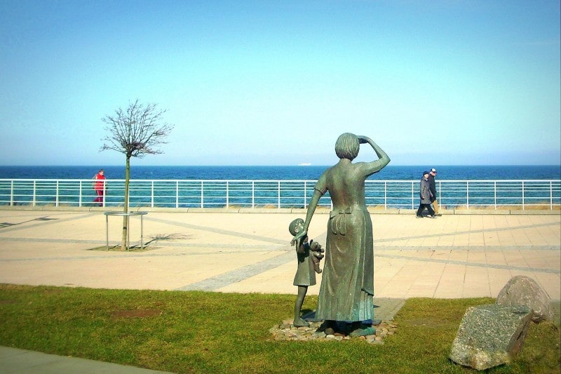 Fischersfrau mit Kind vor dem Haus Meeresblick in Kühlungsborn an der Ostsee